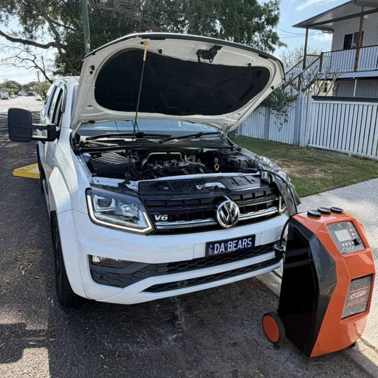 White Volkswagen Amarok V6 with the bonnet up and a Wynn's MultiSERVE machine connected during a mobile service in Brisbane